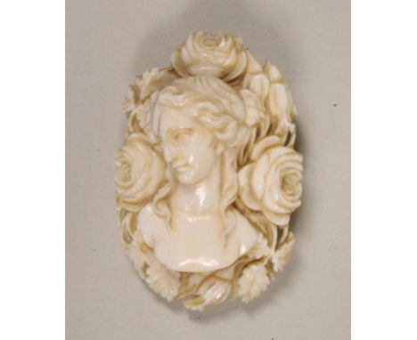 A VICTORIAN IVORY BROOCH, the oval panel carved in high relief with the bust portrait of a young girl with shoulder length ha