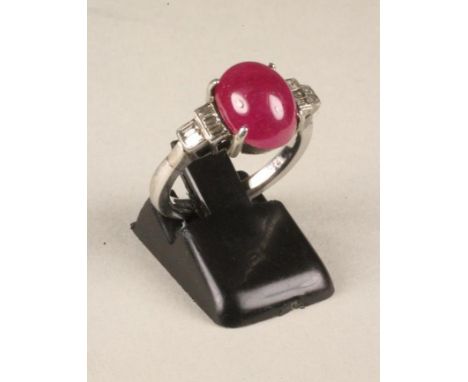 A RUBY AND DIAMOND RING, the oval cabochon polished ruby between shoulders each set with three baguette cut diamonds to a pla