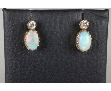 A PAIR OF OPAL AND DIAMOND EAR STUDS, the small round brilliant cut diamond over a cabochon polished opal, unmarked