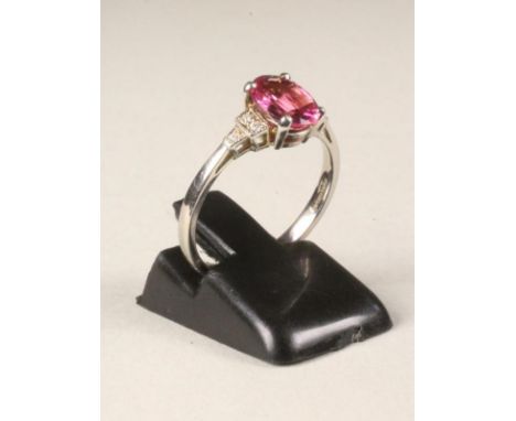 A PINK TOURMALINE DRESS RING, the cushion cut stone claw set to stepped shoulders each set with three small diamonds to a pla