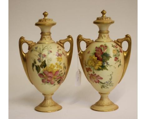 A PAIR OF ROYAL WORCESTER CHINA VASES AND COVERS, 1904, of two handled ovoid form on a low socle, painted in polychrome ename