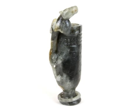 A rare Chinese carved grey jade wine cup with integral ring to foot and a young dragon climbing the outside, H. 21cm.