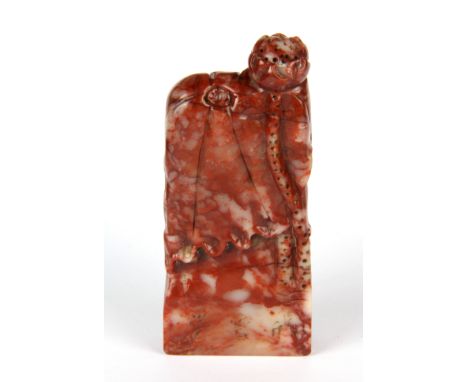 A Chinese carved red and white soapstone seal decorated with lotus, H. 9cm.