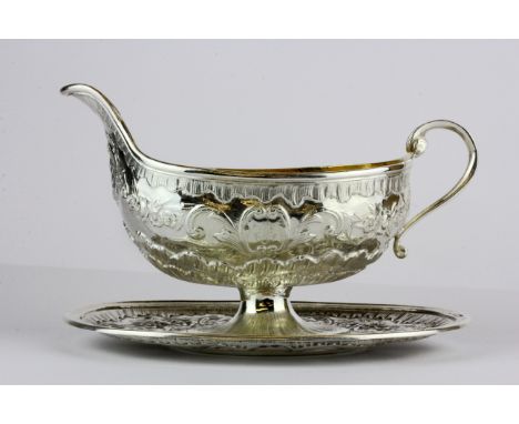 A French hallmarked silver gilt lined sauce boat with attached stand, L. 19cm.