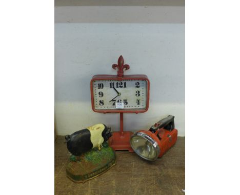 A cast saddle back pig doorstop, a metalwork clock and a vintage Ever Ready torch