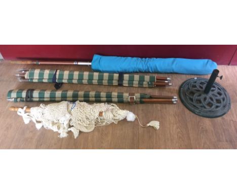 A large garden parasol with cast iron stand. Together a vintage string hammock and pair of green checkered wind breakers. 