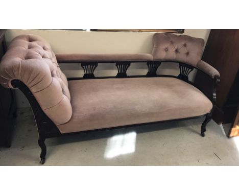 A late Victorian button backed chaise longue with dusky pink velvet upholstery. Carved detail to front, splayed design spindl