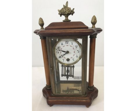 A vintage column mantel clock with bevel edged glass panels and brass finials. Complete with key and pendulum. In working ord