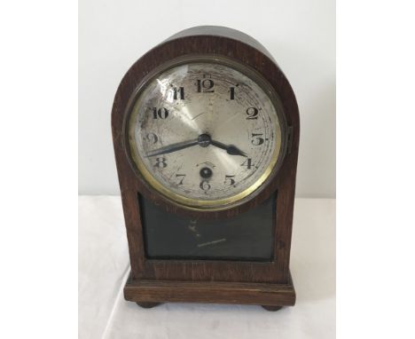 A small dark wood cased mantel clock with bevel edged glass panel. Complete with key and pendulum, in working order. Approx. 