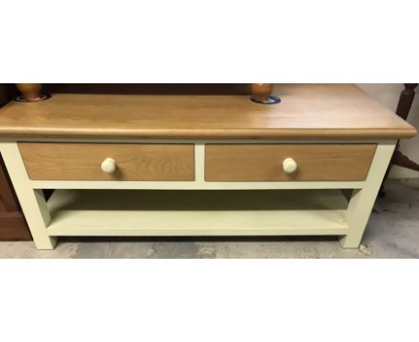 A modern natural wood and cream painted coffee table. With lower shelf and 2 small drawers. Approx. 120 x 55cm deep.