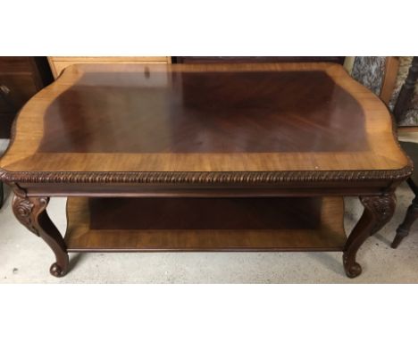 A large reproduction Chippendale style rectangular coffee table with lower shelf. With cabriole style legs and carved detail.