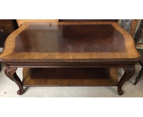 A large reproduction Chippendale style rectangular coffee table with lower shelf. With cabriole style legs and carved detail.