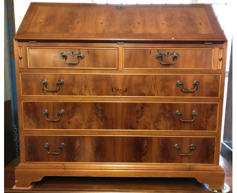 A vintage walnut veneer front 5 drawer bureau with drop down handles. Green leather insert to top and stationery compartments