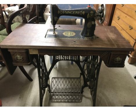 A vintage Singer cast iron based treadle sewing machine with drop leaf end. Lid and belt missing. Approx. 88cm wide.