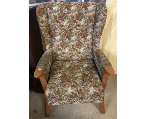A vintage light wood wing back chair with floral tapestry style upholstery.  Approx. 100cm tall.