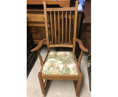 A modern medium wood stick back rocking chair with upholstered seat.  Approx. 106cm tall.