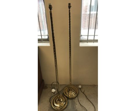 A pair of brass standard lamps with twisted column design. Complete with cream and gold lamp shades. 