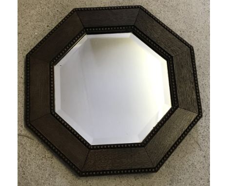 A small vintage octagonal dark oak framed wall hanging mirror. With bevel edged glass and bead decoration to frame. Approx 44