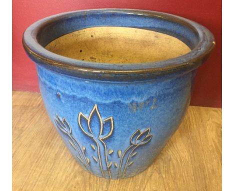 A large blue ceramic garden planter with flower decoration.  Approx 39cm diameter.