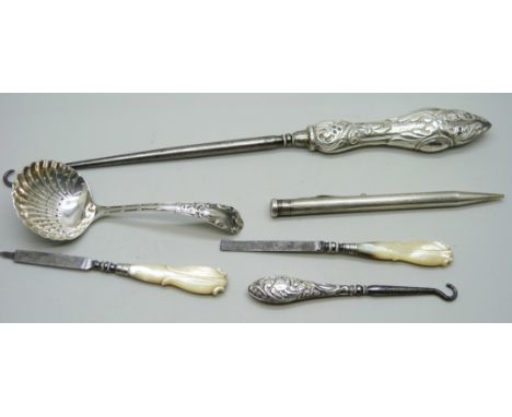 A silver sifter spoon, two silver mounted button hooks, a rolled silver pen, etc. (tweezers a/f)