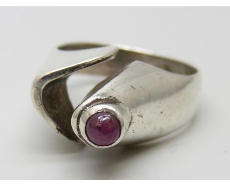 A silver designer ring set with a cabochon ruby, signed R.A.D., size O