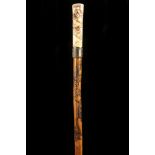 A JAPANESE IVORY HANDLED CANE, the grip carved with a Samurai Warrior, over white metal collar,