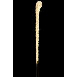 A 19TH CENTURY EUROPEAN IVORY CARVED CANE, the slender handle decorated with bacchanalian figures,