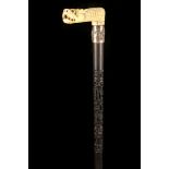 A 19TH CENTURY IVORY HANDLED EBONY WALKING CANE, the L-shaped grip modelled as a Chinese dragon head