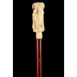 A 19TH CENTURY IVORY HANDLED CANE, the handle carved with two figures by a tree, on later shaft with