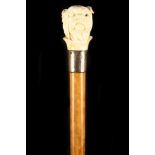 A 19TH CENTURY IVORY HANDLED MALACCA CANE, the grip well worked as a British Bulldog with monocle