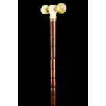AN ANTIQUE IVORY AND SERVES STYLE PORCELAIN HANDLED CANE, the 'T' shaped grip set with an ivory hand