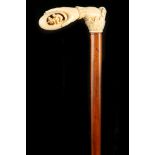 A GOOD 19TH CENTURY MARINE IVORY HANDLED CANE, the grip carved as a hand holding an egg from which