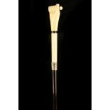 AN ANTIQUE IVORY HANDLED CANE, the grip carved as a hand, with ebony shaft and brass ferrule, 92cm.