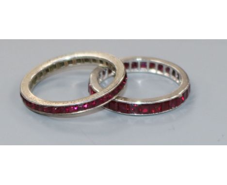 A platinum and ruby eternity ring and one other eternity ring.