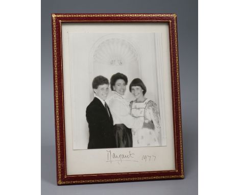 A presentation portrait photograph of Princess Margaret, David Armstrong-Jones and Lady Sarah Chatto, in gilt-tooled red leat