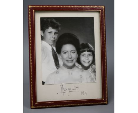 A presentation portrait photograph of Princess Margaret, David Armstrong-Jones and Lady Sarah Chatto, in gilt-tooled red leat
