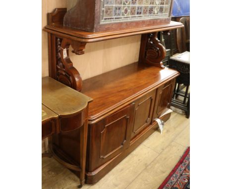 A Victorian mahogany buffet, with panel and shelf above, on openwork S scroll supports, with three panelled doors below, on m