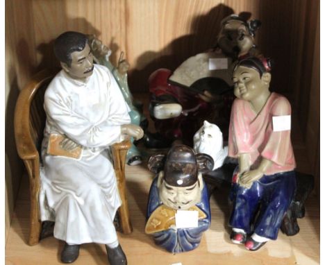 A shelf containing five Chinese ceramic figurines