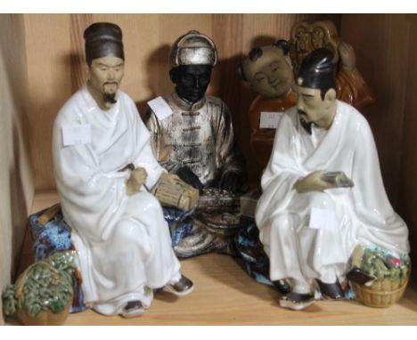 A shelf containing four Chinese ceramic figurines