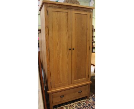 A modern light oak two door wardrobe over single drawer base. 85cm wide x 50cm deep x 183cm high