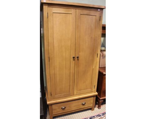 A modern light oak two door wardrobe over single drawer base, external dimensions: 183cm tall, 85cm wide, 50cm deep