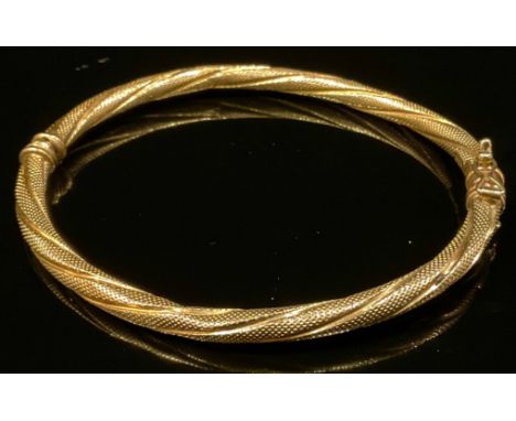 A French 9ct gold fancy twisting hinge bangle, stamped 375 Brev, 5.2g 