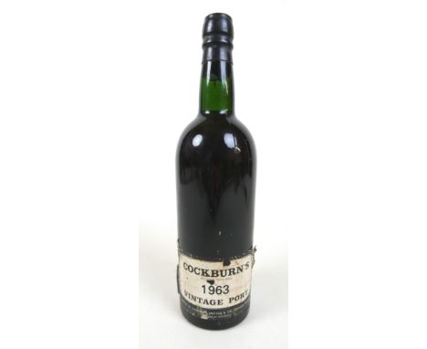 A bottle of Cockburn's 1963 vintage port, level top of the shoulder/base of neck, seal intact. 