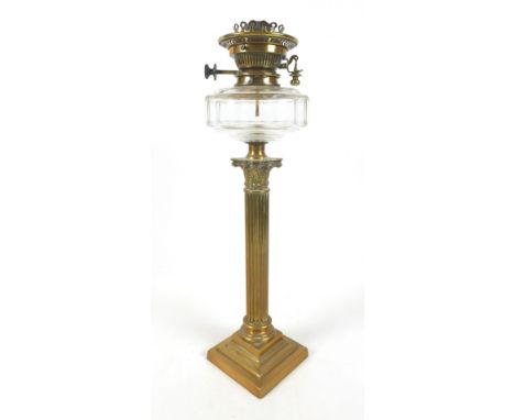 A clear glass and brass paraffin lamp, with fluted Corinthian column support, clear glass faceted reservoir, clear shade and 