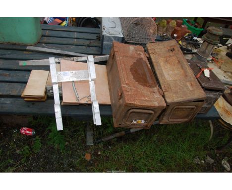 An aluminum ladder stand-off, and three military shell case boxes.