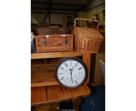 A clock and two wicker baskets.