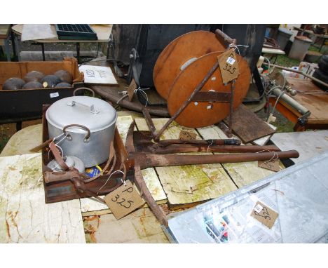 An axe, hacker, pick axe, aluminum pan reel, and old cultivator.