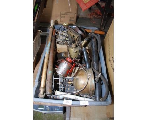 Brass Tilley lamps, hand operated air inflator, axe heads, oil cans and garden sprayer.