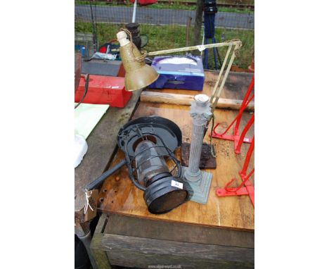 An angle poise lamp, a hurricane lamp, old candlestick and frying pan.