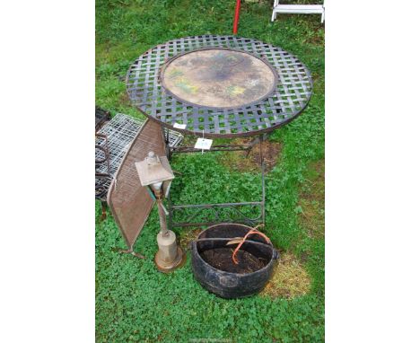 A round metal table 27½" diameter x 28½" high, a spark guard, copper lamp and cast iron swing pot.